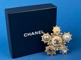 a close up of a box of chanel brooches on a blue background