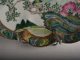 a plate with a painting on it sitting on a table
