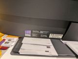 a printer that is sitting on a desk next to a pile of papers