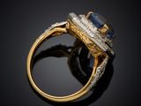 a close up of a gold ring with a sapphire and diamonds