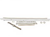 an assortment of brass and silver jewelry on a white background
