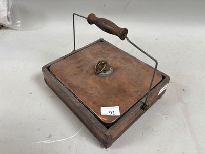 une petite boîte en bois munie d'une poignée, posée sur une table