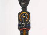a wooden statue of a man with a clock in his hand