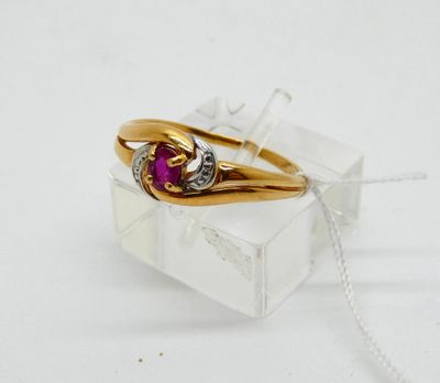 a gold ring with a ruby and diamond on it
