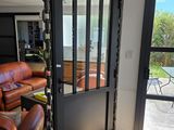 vue d'un salon avec un canapé et une porte-fenêtre coulissante