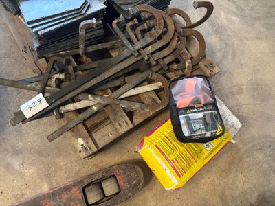 un tas de vieux outils par terre, à côté d'une boîte