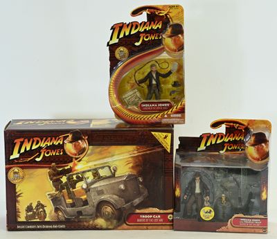 three indiana jones action figures in boxes on a white surface