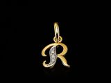 un pendentif en forme d'initiale en or serti de diamants sur fond noir