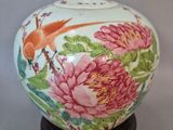 un vase sur lequel sont peints un oiseau et des fleurs