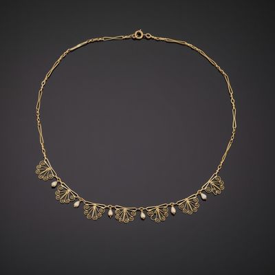 a gold necklace with pearls and leaves