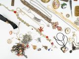 many different types of necklaces and bracelets laid out on a table