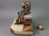 a statue of a woman reading a book on a marble block