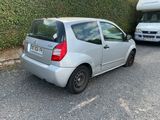 a small silver car parked on the side of the road