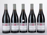 six bouteilles de vin sont alignées sur une table