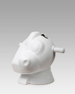 a white pig shaped vase with a toothbrush in it