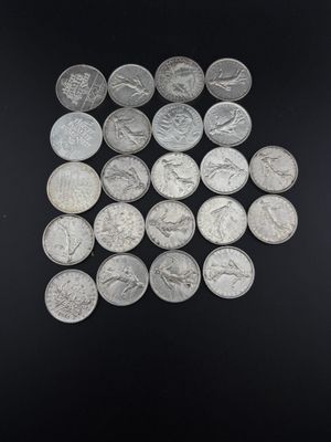 a pile of silver coins sitting on top of a black surface