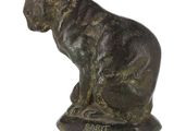 bronze statue of a cat sitting on a rock on a white background