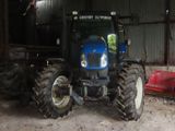 a blue tractor that is parked in a barn
