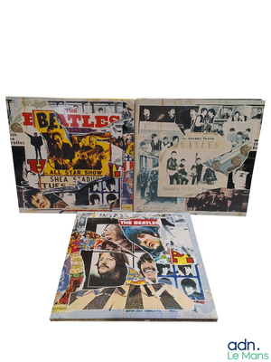 Trois albums des Beatles sont empilés les uns sur les autres sur un fond blanc