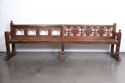 un banc en bois posé dans une pièce, avec un mur derrière lui