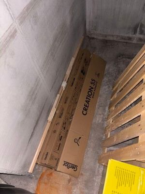 a pile of boxes sitting on the floor next to a trash can