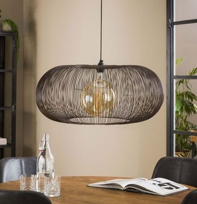 the gray wicker pendant light fixture hangs over a dining room table