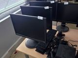many computers on the desks in the room