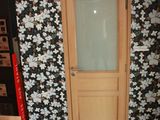 a door in a room with a wallpapered wall and wooden floors