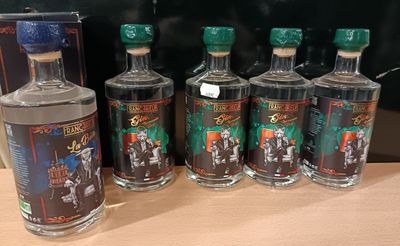 six bouteilles d'alcool sont alignées sur une table