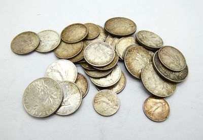a pile of silver coins on a white surface