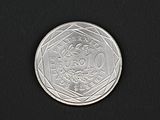 gros plan d'une pièce de monnaie en argent sur une surface noire