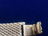 an image of a close up of a metal bracelet on a blue surface