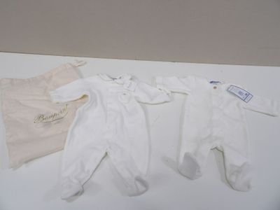 two baby clothes and a bag on a table