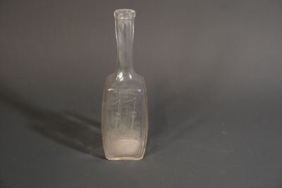 une bouteille en verre transparent contenant un peu de sable