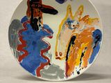 a plate with a painting on it on a white surface