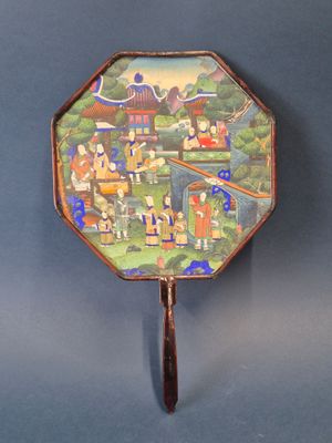 un petit miroir orné d'une image, accroché au mur