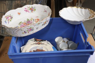 un bac bleu rempli d'assiettes et de bols posé sur une table