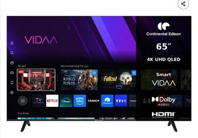 une télévision à écran plat posée sur une table, à côté d'une télécommande