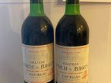 two bottles of wine sitting next to each other on a counter