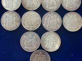 a collection of silver coins in a glass case