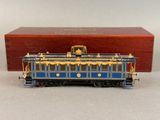 une image représentant un wagon bleu et doré posé sur une table