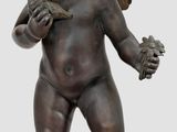 une image représentant la statue d'un enfant avec un oiseau sur l'épaule