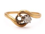 a close up of a gold ring with two diamonds on it