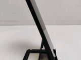 a close up of a cell phone on a stand on a table