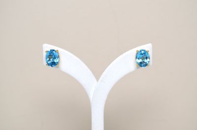 a close up of a pair of earrings on a white stand