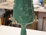 a green vase sitting on a table in a room