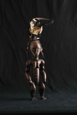 une sculpture africaine représentant une femme avec un oiseau sur la tête