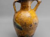 vase jaune et noir muni d'anses, sur un fond gris