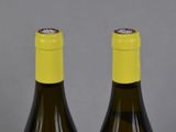 two bottles of wine sitting next to each other on top of a table