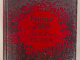 un gros plan d'un livre posé sur une table, avec une couverture rouge